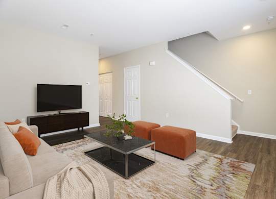 A living room with a couch, coffee table, and a television.